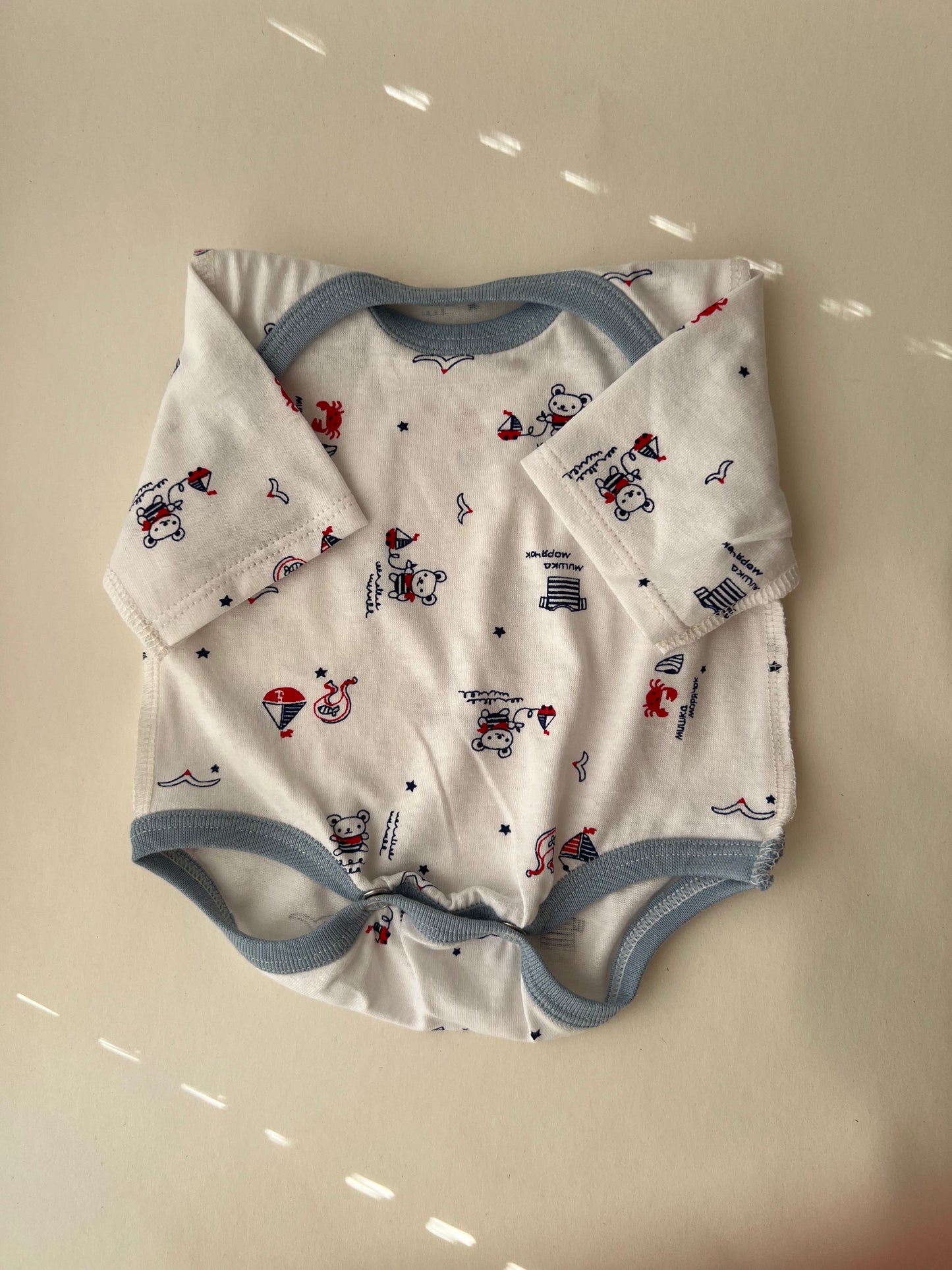 Bodijs “Mazais Jūrnieks” 48 — ar atvērtām kājiņām, garām piedurknēm, šuvumi uz āru